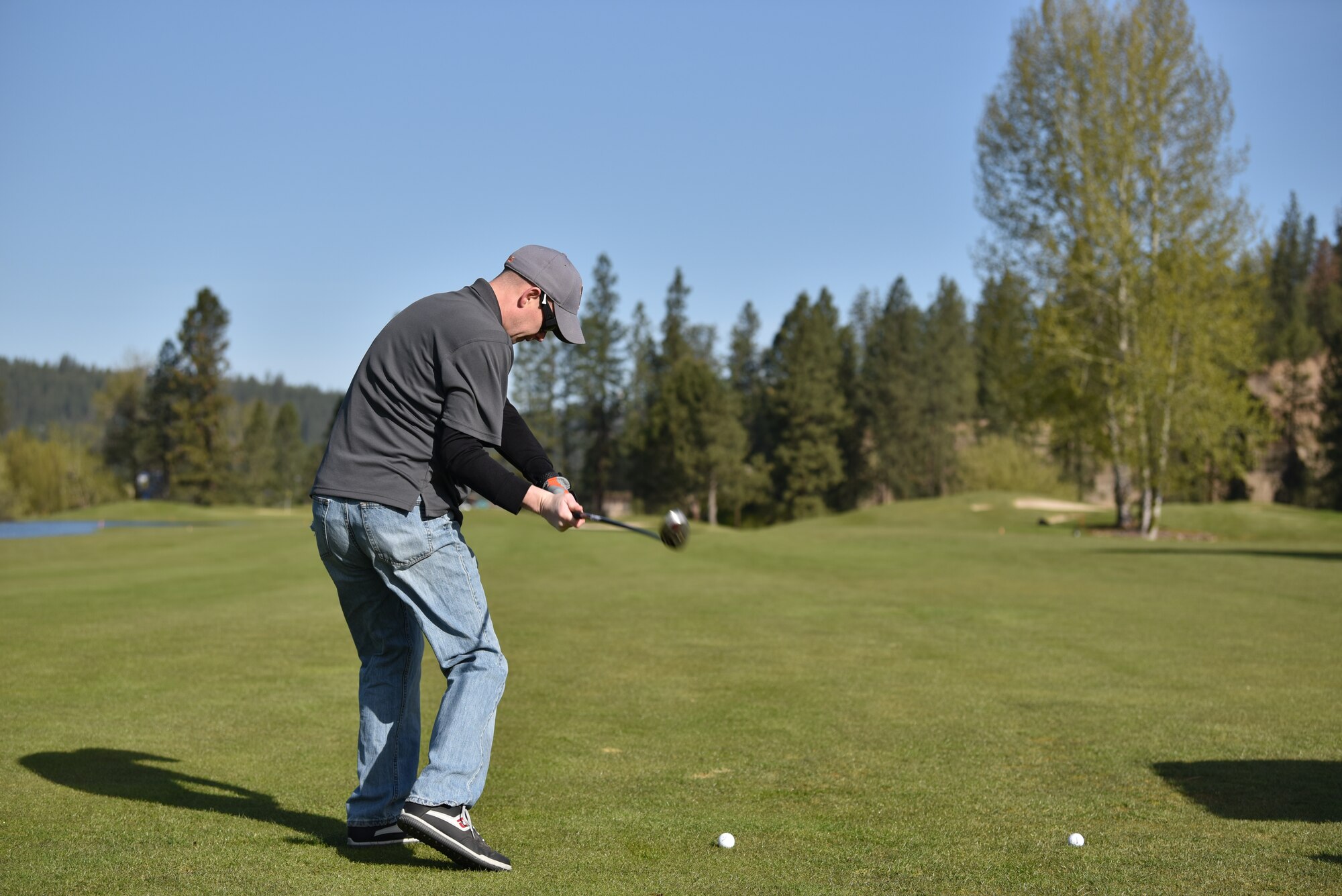 U.S. Air Force Master Sgt. Chris Snyder, 92nd Aircraft Maintenance Squadron productions superintendent, swings at a golf ball, at the Qualchan Golf Course in Spokane, Washington, May 3, 2019.