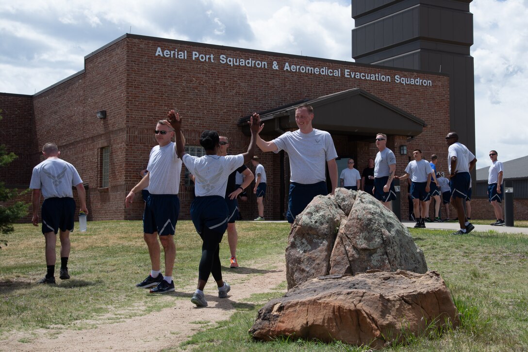 Staff Sgt. Jennifer Mensah-Bonsu, a 39th Aerial Port Squadron air transportation specialist, high fives her peers after completing the 5th annual Port Dawg Memorial Run May 4, 2019, at Peterson Air Force Base, Colorado.