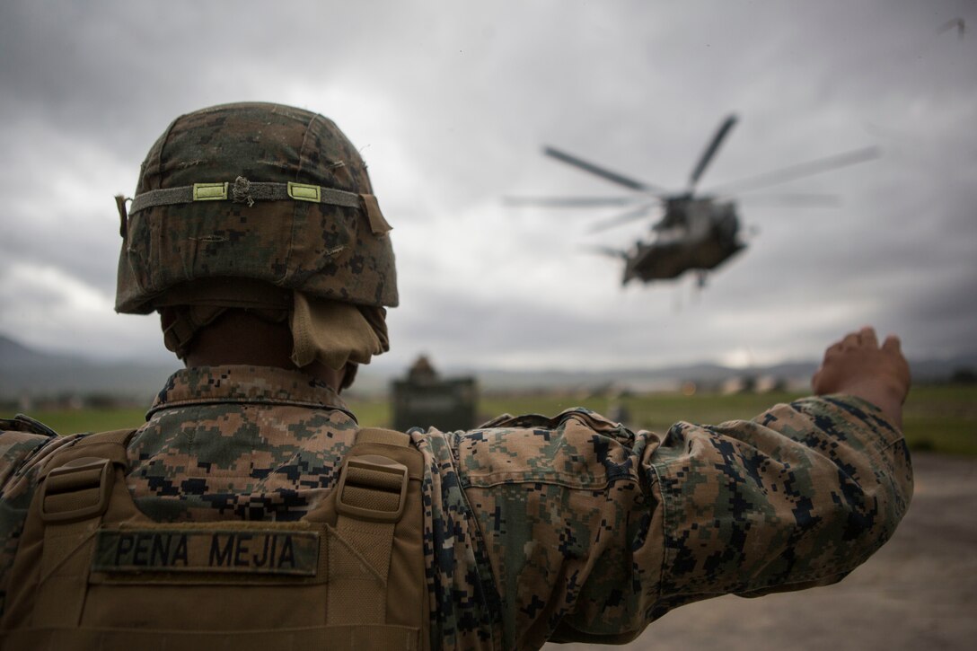 Marine Corps landing support specialist with Special Purpose Marine Air-Ground Task Force–Southern Command guides CH-53E Super Stallion on Soto Cano Air Base, Honduras, July 10, 2015 (U.S. Marine Corps/Abraham Lopez)