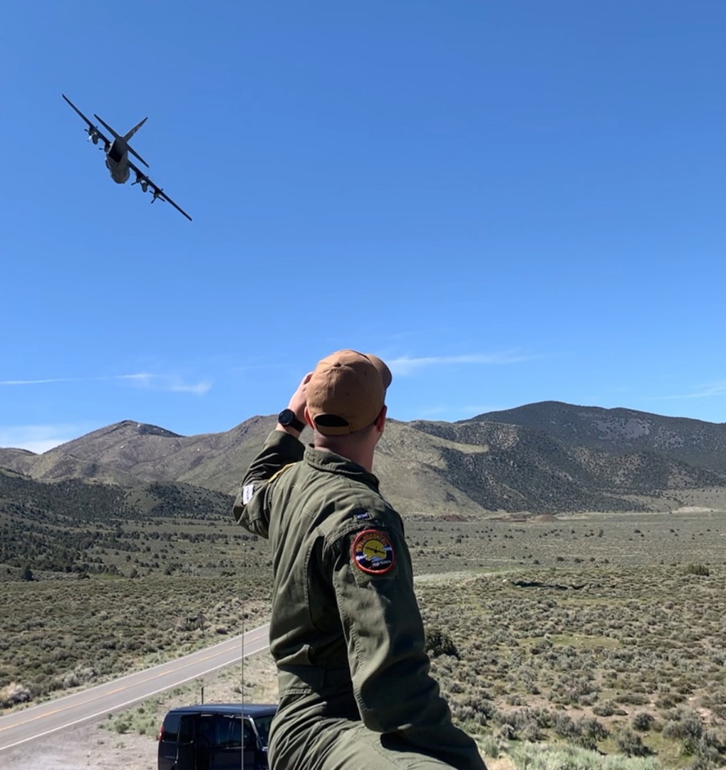 An Air National Guard member from the 192nd Airlift Squadron watches as a Nevada Air National Guard C-130 flies over the Naval Air Station Fallon Range Training Complex during the Resolute Hunter Exercise, a joint exercise with the U.S. Navy, Nevada Air National Guard and Nevada Army National Guard on April 25, 2019.