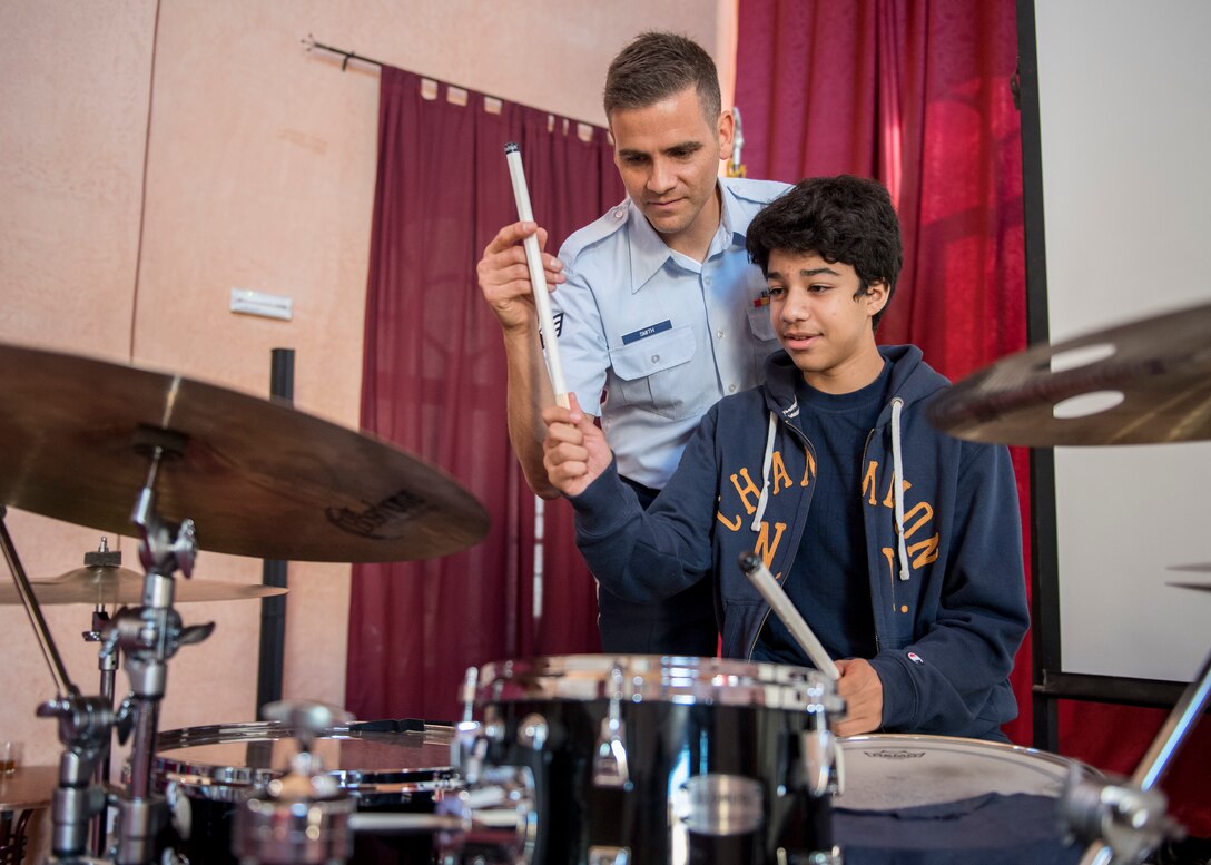 Airman teaching student on drumset