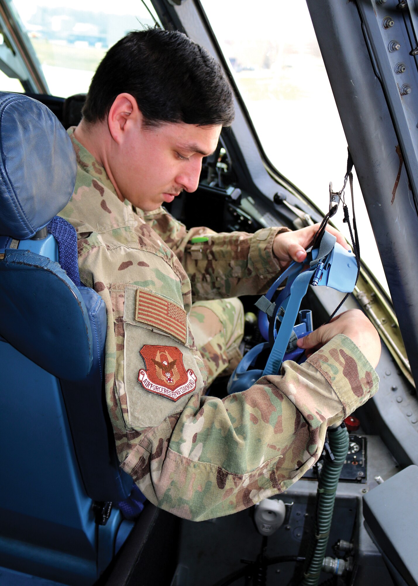 Senior Airman Devin Litton, 445th Operations Support Squadron aircrew flight equipment technician, checks each component of the quick-don mask while installing it in the cockpit of a C-17 Globemaster III at Wright-Patterson Air Force Base, Ohio.