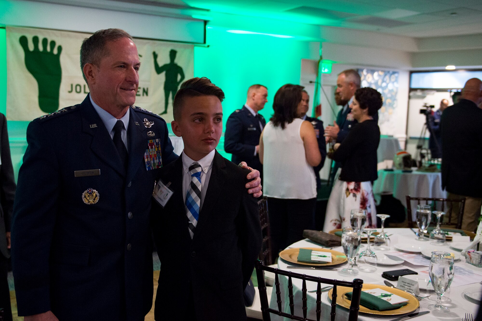 Air Force Chief of Staff Gen. David L. Goldfein, poses for a photo with young attendee Jack Flournoy, during the banquet celebrating the 50th reunion of the Jolly Green Association (JGA), May 4, 2019, in Fort Walton Beach, Fla. The JGA presented Airmen from the 41st Rescue Squadron (RQS) and the 48th RQS with the Rescue Mission of the Year award; the only non Air Force rescue award recognized by the Air Force. (U.S. Air Force Photo by Staff Sgt. Janiqua P. Robinson)