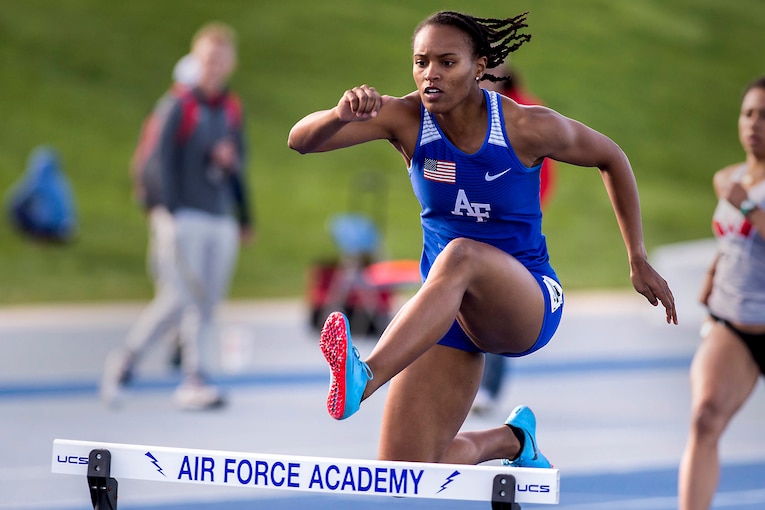 An athlete jumps over a hurdle.