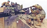 Brig. Gen. Leigh Tingey, deputy commanding general of 1st Armored Division, sits inside a Bradley Fighting Vehicle as Pfc. Natnael Getahun, an infantryman with the division's 2nd Brigade Combat Team, fixes the bore sight to ensure accuracy during a live-fire exercise at Drawsko Pomorskie Training Area, Poland, March 24, 2019. The brigade recently conducted a no-notice deployment from Texas to Eastern Europe in an effort to test and ensure the rapid capabilities of units deploying to that region.