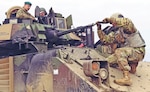 Brig. Gen. Leigh Tingey, deputy commanding general of 1st Armored Division, sits inside a Bradley Fighting Vehicle as Pfc. Natnael Getahun, an infantryman with the division's 2nd Brigade Combat Team, fixes the bore sight to ensure accuracy during a live-fire exercise at Drawsko Pomorskie Training Area, Poland, March 24, 2019. The brigade recently conducted a no-notice deployment from Texas to Eastern Europe in an effort to test and ensure the rapid capabilities of units deploying to that region.