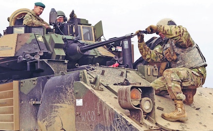 Brig. Gen. Leigh Tingey, deputy commanding general of 1st Armored Division, sits inside a Bradley Fighting Vehicle as Pfc. Natnael Getahun, an infantryman with the division's 2nd Brigade Combat Team, fixes the bore sight to ensure accuracy during a live-fire exercise at Drawsko Pomorskie Training Area, Poland, March 24, 2019. The brigade recently conducted a no-notice deployment from Texas to Eastern Europe in an effort to test and ensure the rapid capabilities of units deploying to that region.