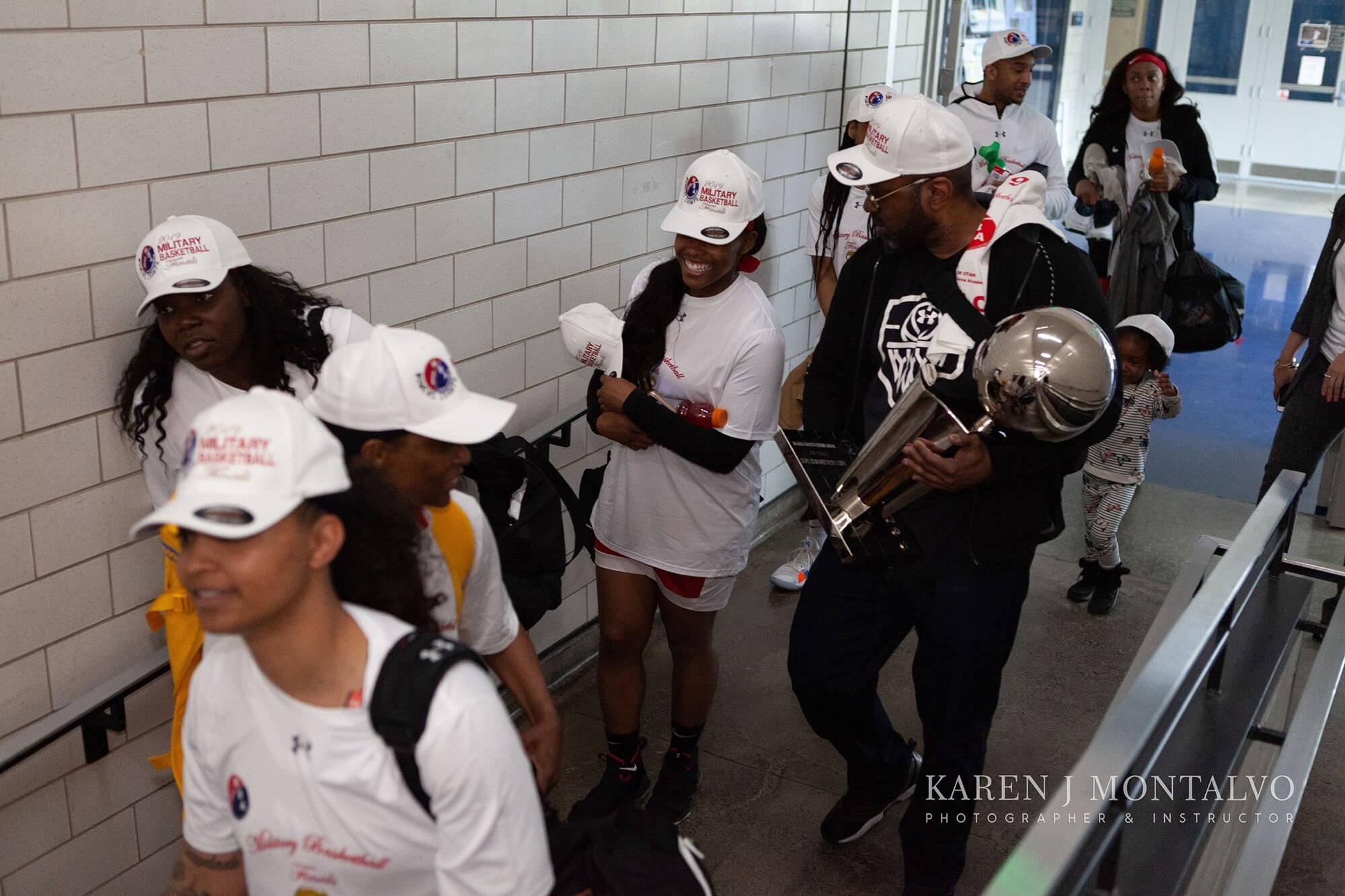 The Joint Base Langley-Eustis Lady Raptors and their coach, U.S. Air Force Retired Bruce Smith, walk through a hall at the Military Basketball Association Finals tournament game, at Colorado Springs, Colorado, April 14, 2019.