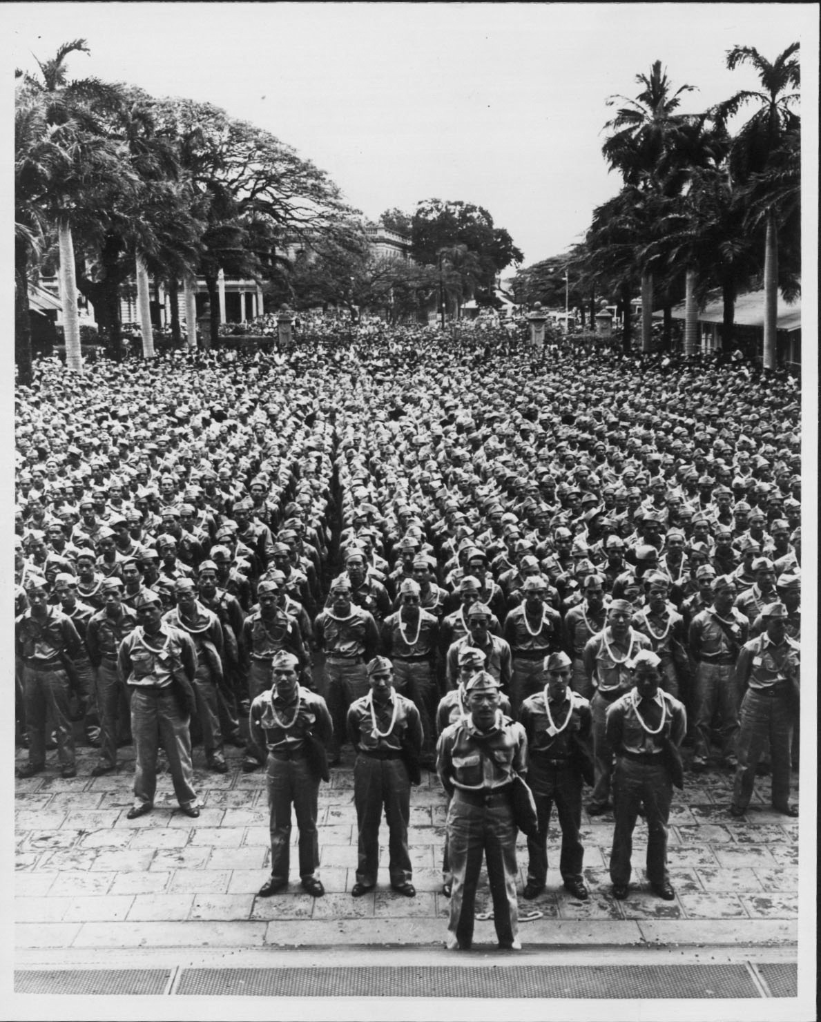The 442nd Regimental Combat Team, made up of Japanese-American soldiers, stands in formation at Iolani Palace, Hawaii, prior to a departure for training, March 1943.