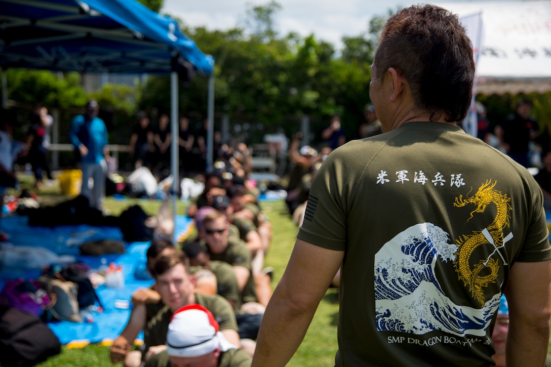 Nobuhiro Hirahara, head coach for the Single Marine Program dragon boat team, leads service members through a series of warm up exercises during the 45th Annual Naha Dragon Boat Race May 5, 2019,  at Naha Port, Okinawa, Japan. Local and military communities participated in the famous race, also known as the "Haarii." The SMP team placed first in their preliminary heat.