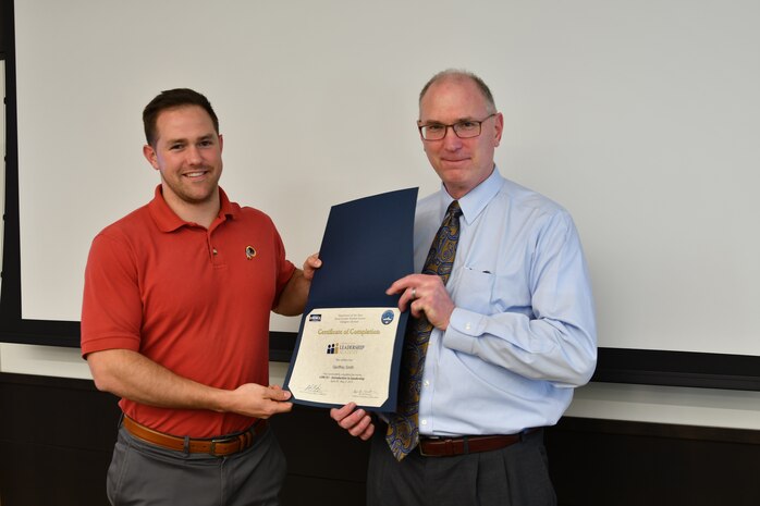 IMAGE: Gill Goddin, Naval Surface Warfare Center Dahlgren Division (NSWCDD) chief engineer, presents a certificate to a NSWCDD Leadership 101 graduate.