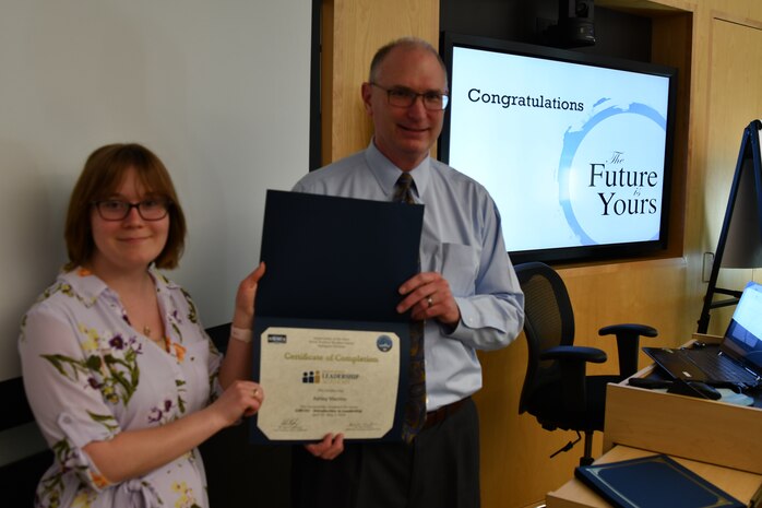 IMAGE: Gill Goddin, Naval Surface Warfare Center Dahlgren Division (NSWCDD) chief engineer, presents a certificate to a NSWCDD Leadership 101 graduate.