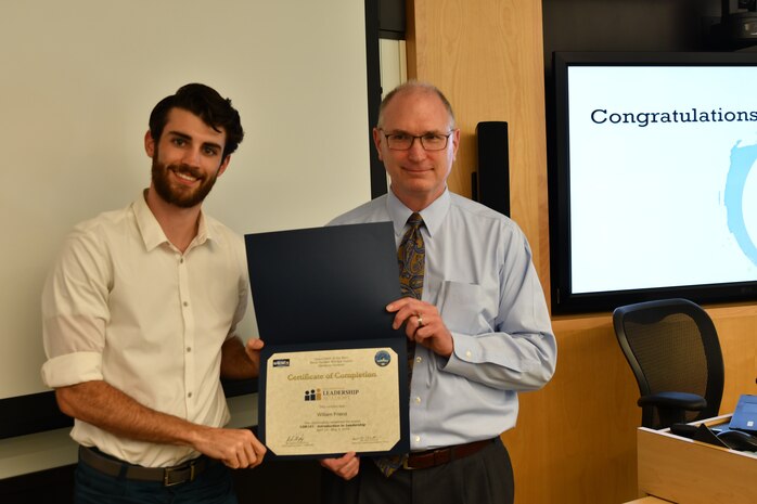 IMAGE: Gill Goddin, Naval Surface Warfare Center Dahlgren Division (NSWCDD) chief engineer, presents a certificate to a NSWCDD Leadership 101 graduate.