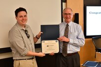 IMAGE: Gill Goddin, Naval Surface Warfare Center Dahlgren Division (NSWCDD) chief engineer, presents a certificate to a NSWCDD Leadership 101 graduate.