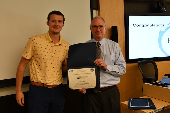 IMAGE: Gill Goddin, Naval Surface Warfare Center Dahlgren Division (NSWCDD) chief engineer, presents a certificate to a NSWCDD Leadership 101 graduate.