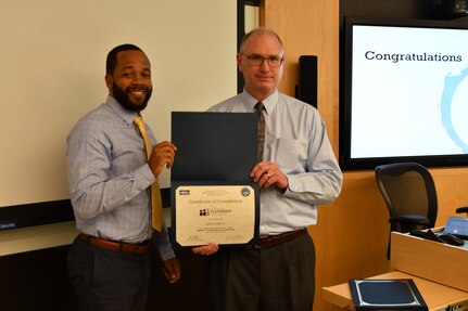 IMAGE: Gill Goddin, Naval Surface Warfare Center Dahlgren Division (NSWCDD) chief engineer, presents a certificate to a NSWCDD Leadership 101 graduate.