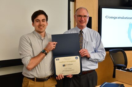 IMAGE: Gill Goddin, Naval Surface Warfare Center Dahlgren Division (NSWCDD) chief engineer, presents a certificate to a NSWCDD Leadership 101 graduate.