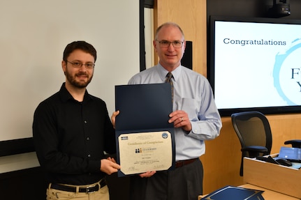 IMAGE: Gill Goddin, Naval Surface Warfare Center Dahlgren Division (NSWCDD) chief engineer, presents a certificate to a NSWCDD Leadership 101 graduate.