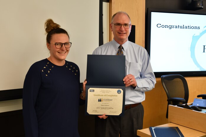 IMAGE: Gill Goddin, Naval Surface Warfare Center Dahlgren Division (NSWCDD) chief engineer, presents a certificate to a NSWCDD Leadership 101 graduate.