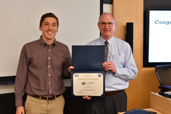 IMAGE: Gill Goddin, Naval Surface Warfare Center Dahlgren Division (NSWCDD) chief engineer, presents a certificate to a NSWCDD Leadership 101 graduate.