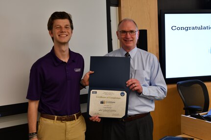 IMAGE: Gill Goddin, Naval Surface Warfare Center Dahlgren Division (NSWCDD) chief engineer, presents a certificate to a NSWCDD Leadership 101 graduate.