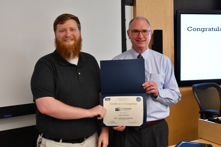 IMAGE: Gill Goddin, Naval Surface Warfare Center Dahlgren Division (NSWCDD) chief engineer, presents a certificate to a NSWCDD Leadership 101 graduate.