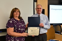 IMAGE: Gill Goddin, Naval Surface Warfare Center Dahlgren Division (NSWCDD) chief engineer, presents a certificate to a NSWCDD Leadership 101 graduate.