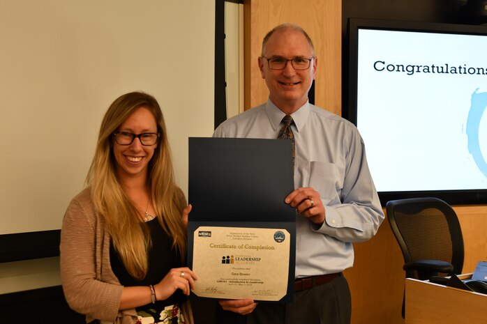 IMAGE: Gill Goddin, Naval Surface Warfare Center Dahlgren Division (NSWCDD) chief engineer, presents a certificate to a NSWCDD Leadership 101 graduate.