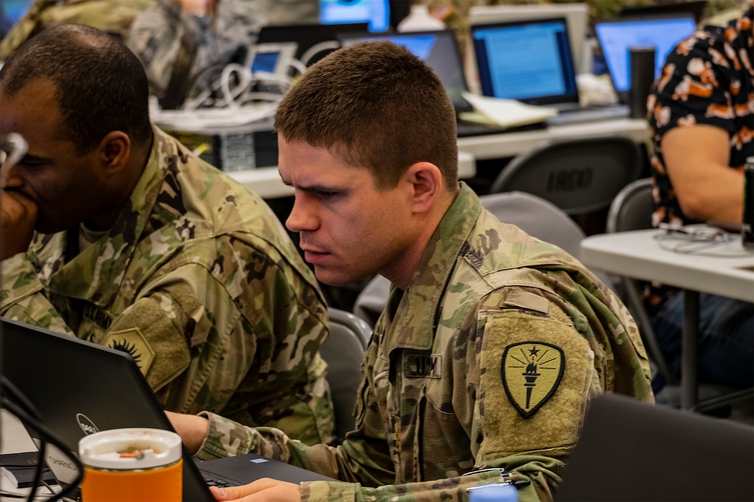 A soldier works at a computer station.