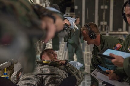 U.S. Air Force Senior Airman Matthew Wright, charge medical technician with the 315th Aeromedical Evacuation Squadron at JB Charleston, South Carolina, checks on his mock paitent, Civil Air Patrol cadet Elkin, during a National Disaster Management System exercise May 7, 2019, en route to Greenville, S.C. Approximately 30 CAP cadets volunteered as mock patients to assist in the NDMS training flight that helped the 315AES prepare for real life scenerios.
