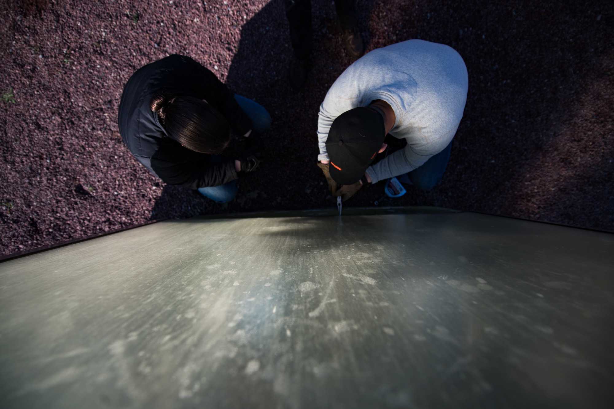 U.S. Air Force Airman 1st Class Rachel Miller, 435th Construction Training Squadron power production journeyman, and Staff Sgt. Matthew Evans, 435th CTS structural contingency instructor, disassemble a display case, housing a WWII aircraft engine, at a memorial in Picauville, France, April 30, 2019. Before arriving to Picauville, the 435th CTS team prepared a new display case to replace the damaged one. (U.S. Air Force photo by Staff Sgt. Devin Boyer)