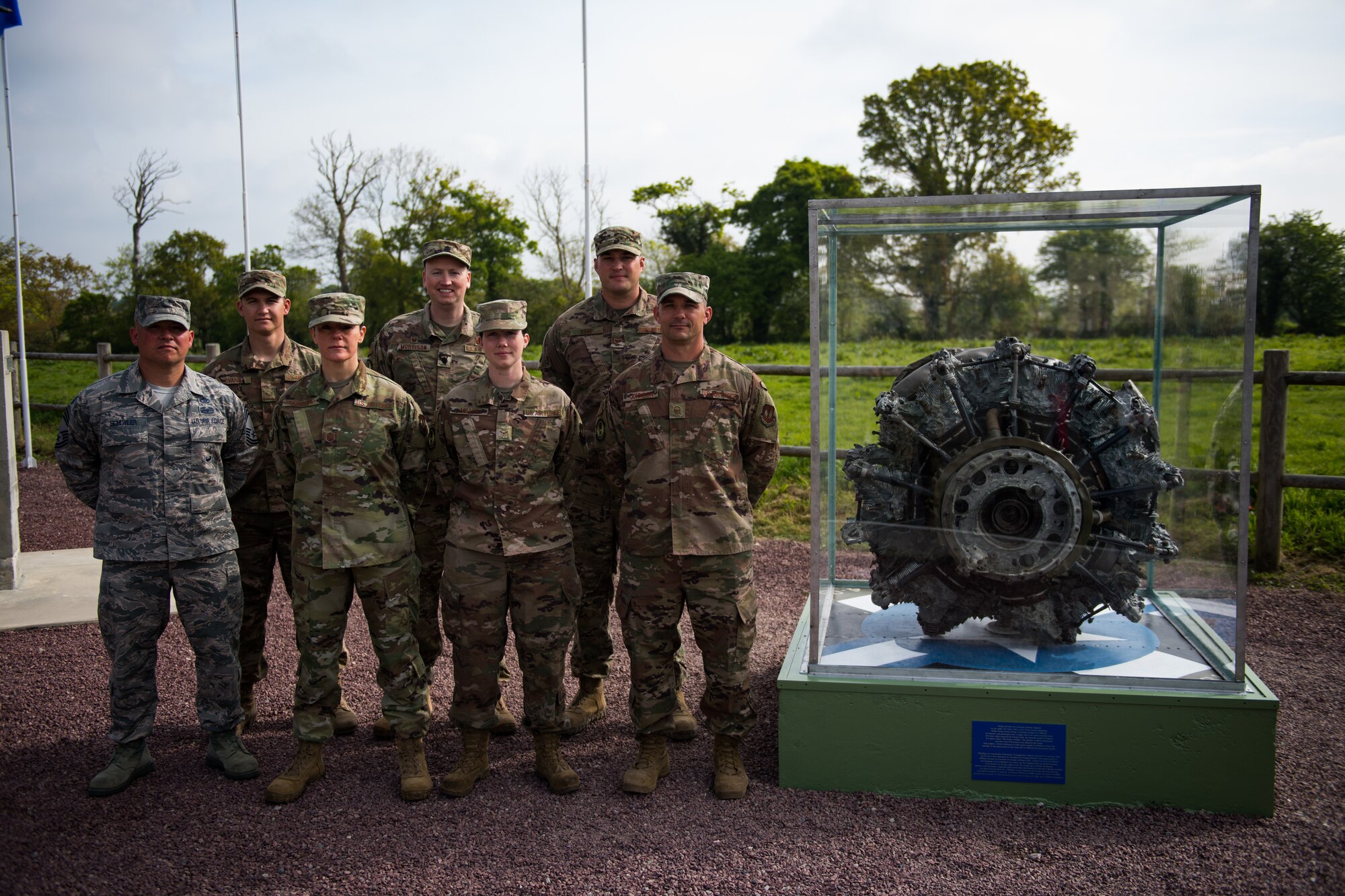 U.S. Air Force Airmen assigned to the 435th Construction Training Squadron, stand at parade rest next to a newly refurbished WWII aircraft engine display in Picauville, France, May 1, 2019. The Airmen worked together to refurbish the display case and the surrounding memorial in preparation for the 75th Anniversary of D-Day. (U.S. Air Force photo by Staff Sgt. Devin Boyer)