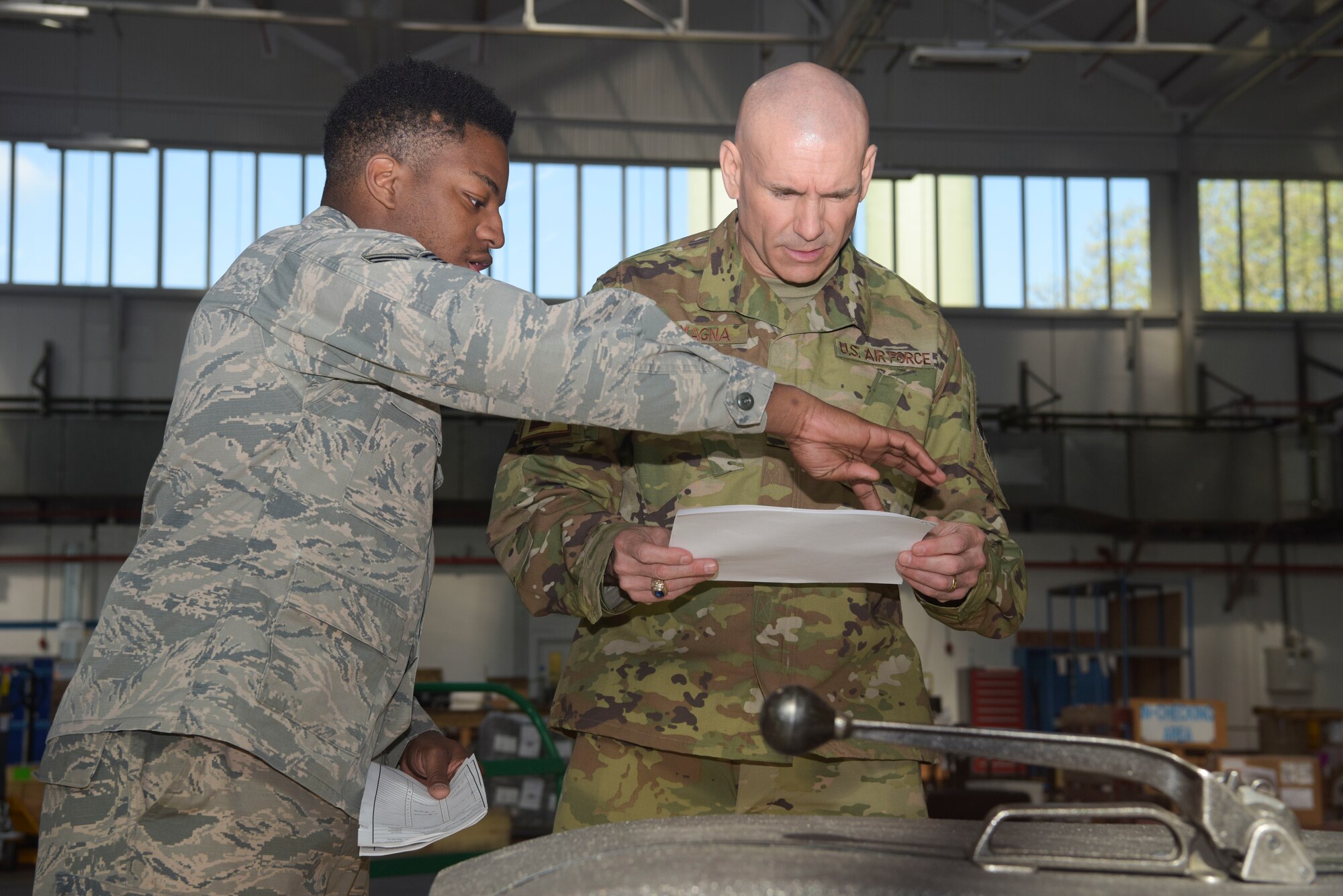 U.S. Air Force Senior Airman Kentral White, 100th Logistics Readiness Squadron traffic management journeyman, and Maj. Anthony LaMagna, 100th Logistics Readiness Squadron commander, look over shipping orders for an outbound package at RAF Mildenhall, England, May 2, 2019. LaMagna participates in ‘Walking with Warriors’ once a week, where all leadership leave their desk and interact with Airmen, from top leadership on down.   (U.S. Air Force photo by Senior Airman Alexandria Lee)