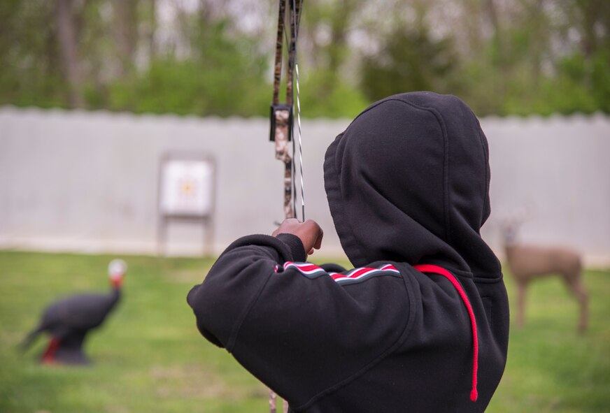 Child taking aim with an archery bow.