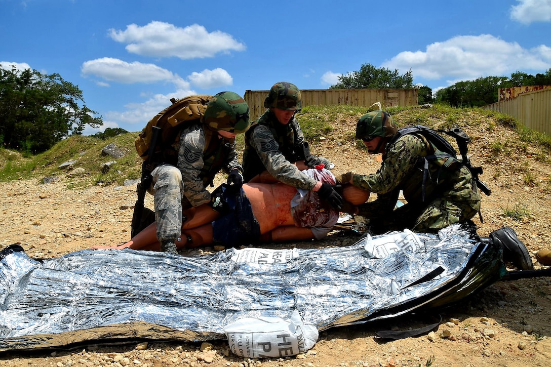 Reserve Citizen Airmen medical technicians and a Navy Reserve corpsman care for a simulated wounded patient during Operation Joint Medic May 5, 2019 at Joint Base San Antonio-Camp Bullis, Texas.
