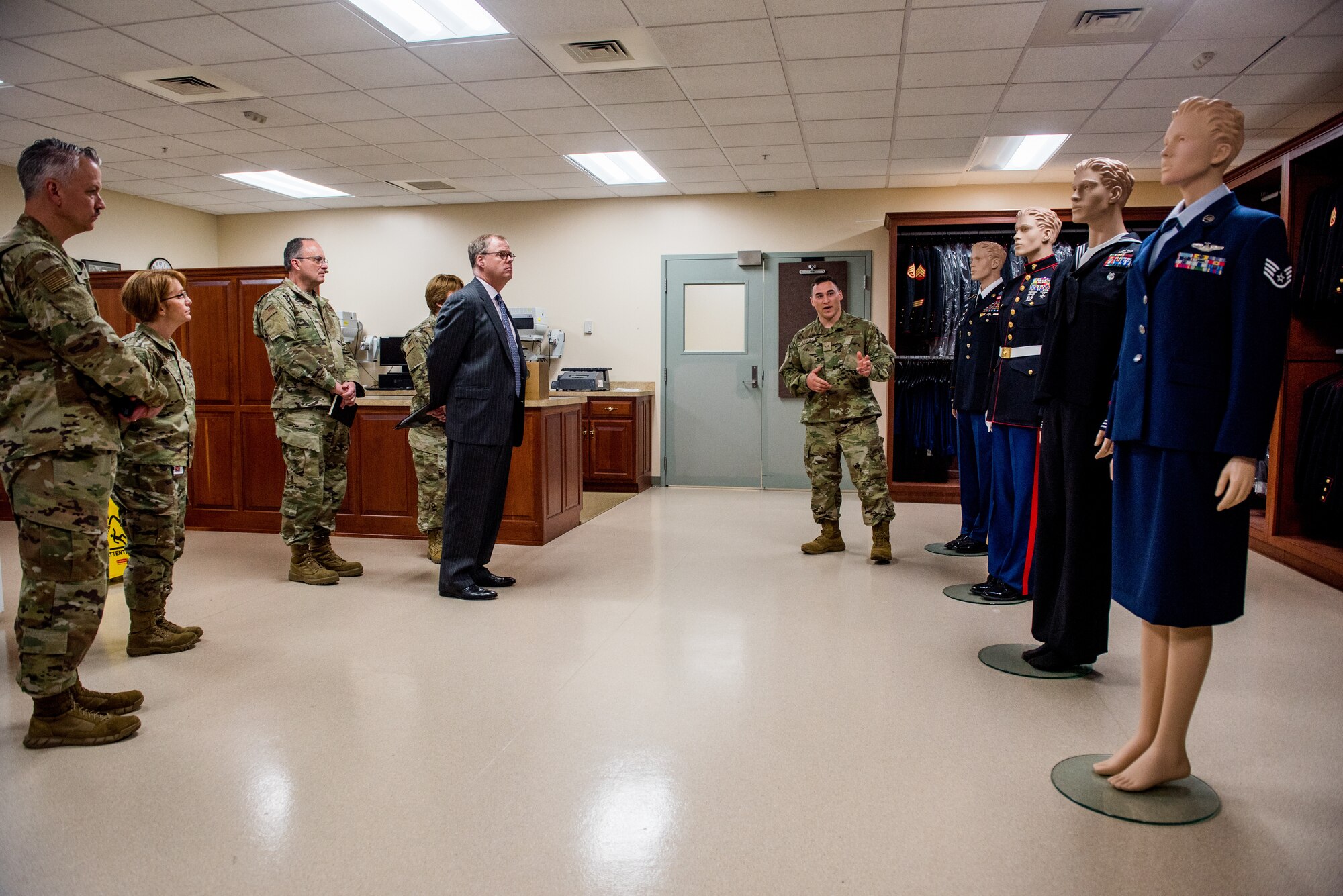 Senior Airman John Juarez, Air Force Mortuary Affairs Operations uniform section, briefs Thomas McCaffery, the Principal Deputy Assistant Secretary of Defense for Health Affairs, Lt. Gen. Dorothy Hogg, the Air Force Surgeon General, Maj. Gen. Lee Payne, the Assistant Director for Combat Support for the Defense Health Agency and Chief Master Sgt. George Cum, Medical Enlisted Force and Enlisted Corps chief, at AFMAO on Dover Air Force Base, Delaware, May 3, 2019. Service members are provided brand-new dress uniforms, proper decorations and medals prior to departing AFMAO. (U.S. Air Force photo by Staff Sgt. Damien Taylor)