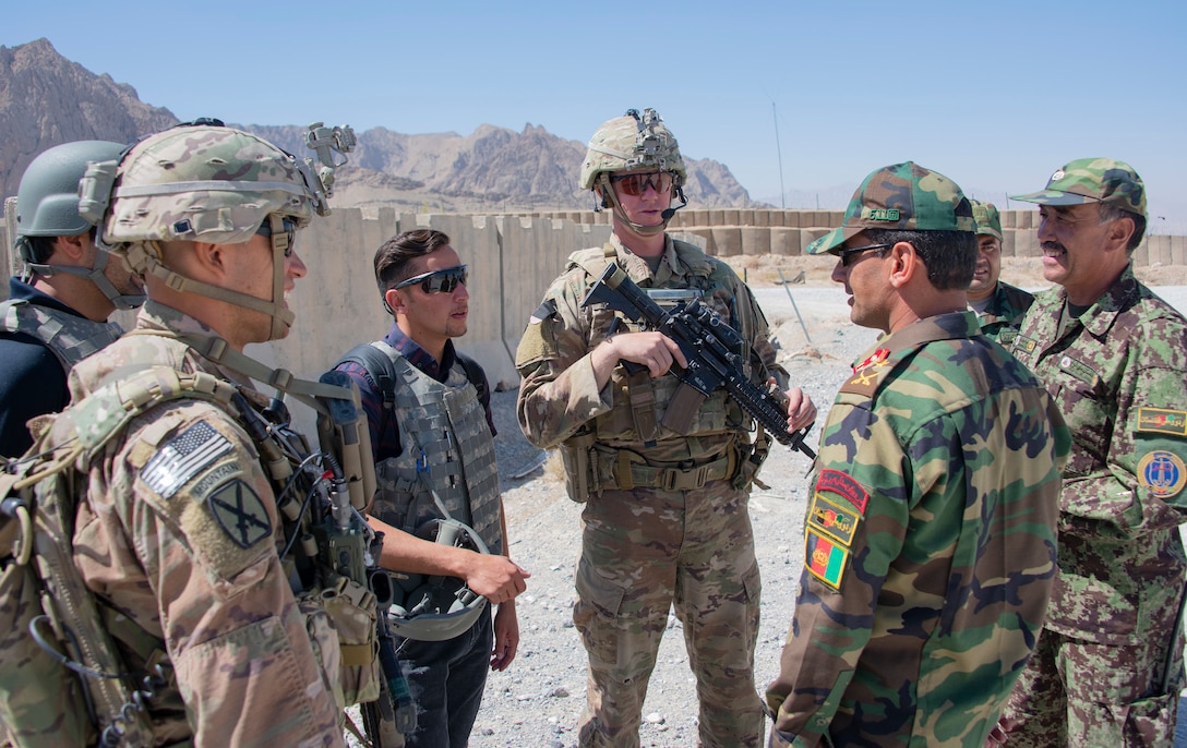 Sgt. 1st Class Jeremiah Velez, left, and Capt. David Zak, center, both advisors with the 1st Security Force Assistance Brigade's 3rd Squadron, speak with their Afghan National Army counterparts during a routine fly-to-advise mission at Forward Operating Base Altimur, Afghanistan, Sept. 19, 2018. (Photo Credit: Sean Kimmons)