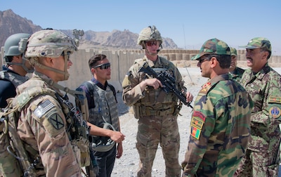 Sgt. 1st Class Jeremiah Velez, left, and Capt. David Zak, center, both advisors with the 1st Security Force Assistance Brigade's 3rd Squadron, speak with their Afghan National Army counterparts during a routine fly-to-advise mission at Forward Operating Base Altimur, Afghanistan, Sept. 19, 2018. (Photo Credit: Sean Kimmons)