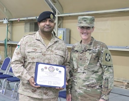 Kuwait Col. Raed Altajalli, assistant director of Kuwait North Military Medical Complex, and U.S. Army Col. Ellen Shannon-Ball, 452d Combat Support Hospital commander, stand together after he receives an award at Camp Arifjan, Kuwait, May 6, 2019.