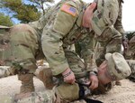A Soldier attending the Brigade Combat Team Trauma Training (BCT3) Course at Joint Base San Antonio-Camp Bullis practices applying a tourniquet.