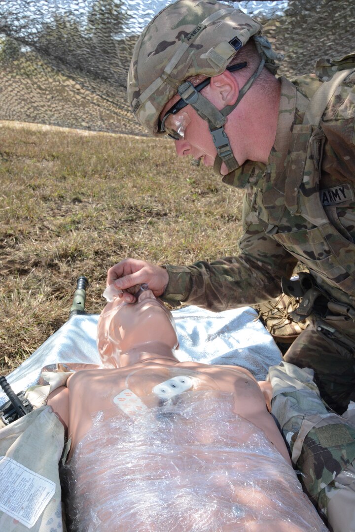 A combat medic training at Joint Base San Antonio-Camp Bullis treats a patient simulator on Tactical Combat Casualty Care in a field environment at the U.S. Army Medical Department Center and School, Health Readiness Center of Excellence.