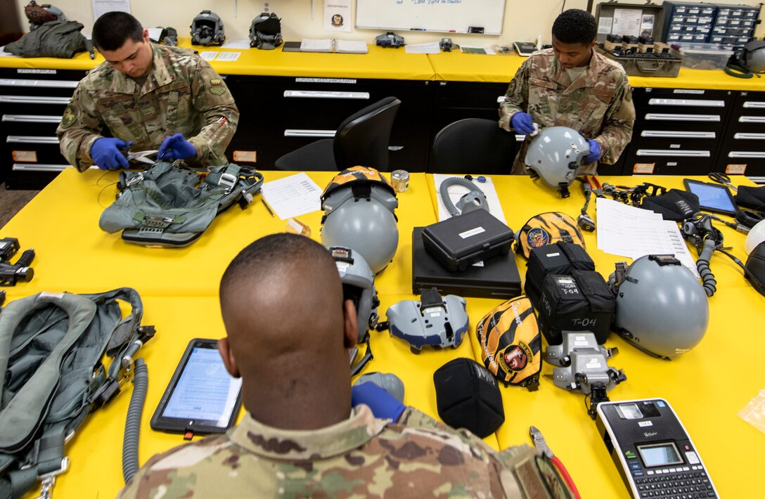 From left, U.S. Air Force Airman 1st Class Manuel Mendoza Carrizoa, Airman 1st Class Orlando Harris and Senior Airman Devin Schumpert, 20th Operations Support Squadron aircrew flight equipment (AFE) technicians, inspect flight gear at Shaw Air Force Base, S.C., May 8, 2019.