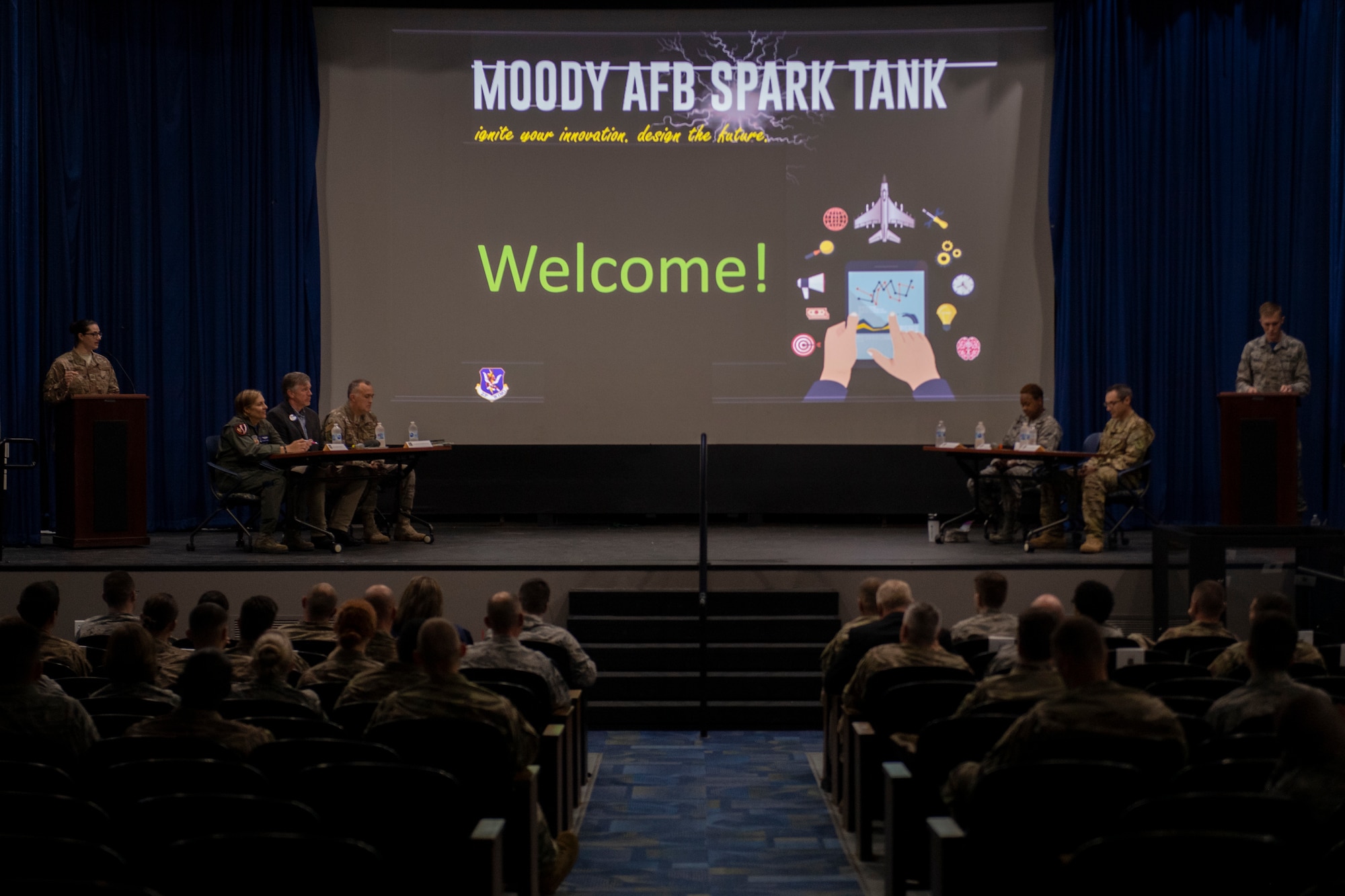 Audience members listen as the emcees introduce the judges during the second annual Moody Spark Tank competition May, 3, 2019, at Moody Air Force Base, Ga. The competition allows Airmen to showcase their ingenuity by presenting various time and money saving ideas that can benefit the Air Force. Teams were given five minutes to present their ideas, followed by four minutes of questions from the judges and culminating in a final decision round to announce the winners. (U.S. Air Force photo by Airman 1st Class Joseph P. Leveille)
