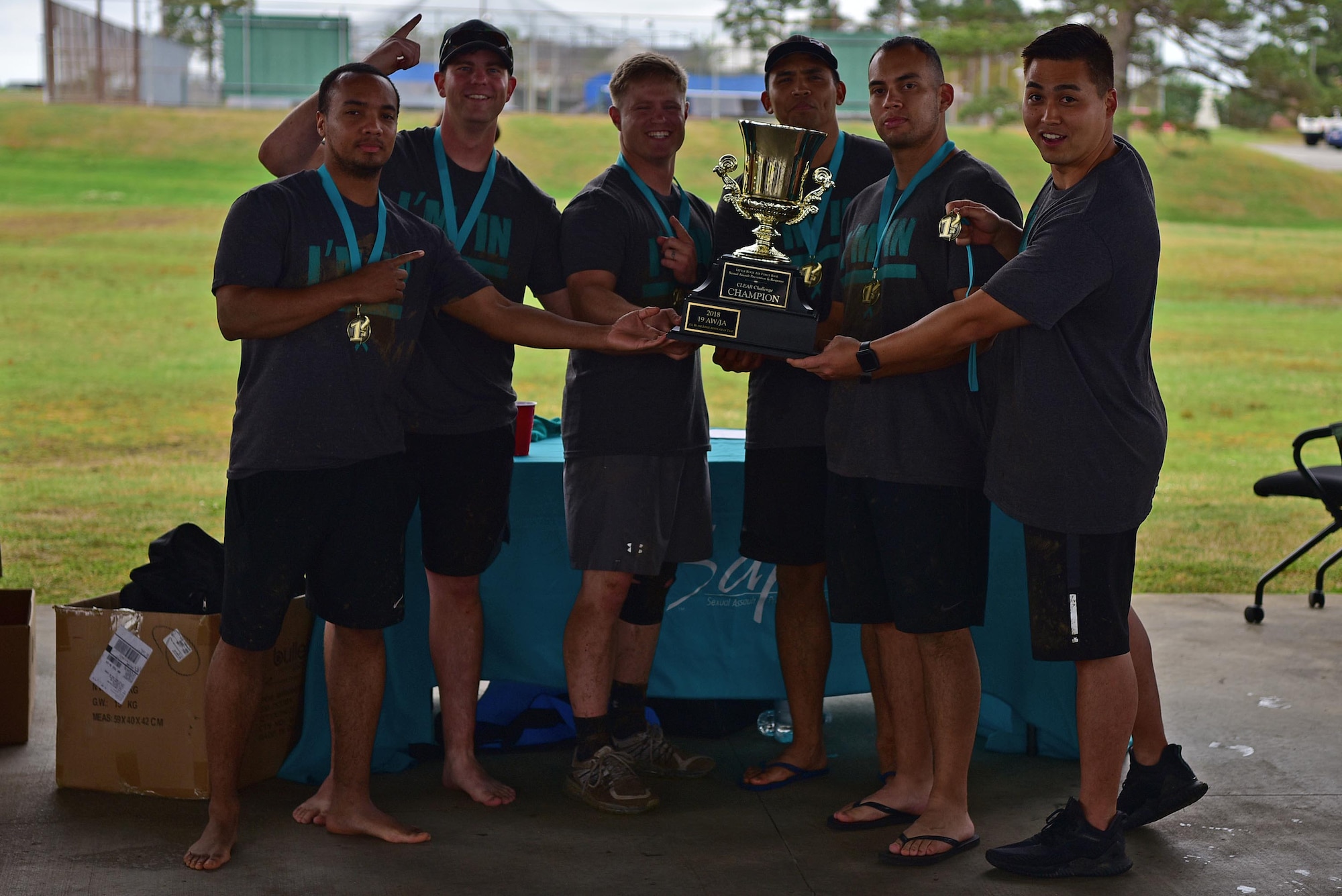 Airmen hold up a trophy after winning the CLEAR challenge.