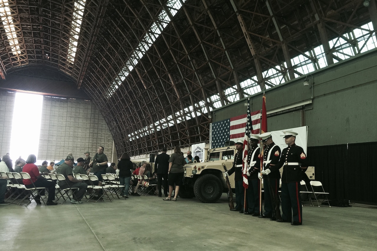 People stand in an empty hangar