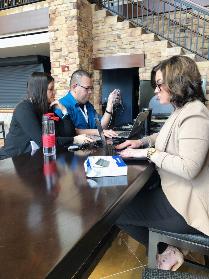 (Left) Latisha Dixie McSwain-Zeman, S-6 Communications department, assists Isaac Padilla, S-7, Security and Emergency Services Department; and Rhea Andrews, S-4 Supply, with preparations for their presentation of their VPP Safety Star talk in Tucson, Arizona, April 17.
