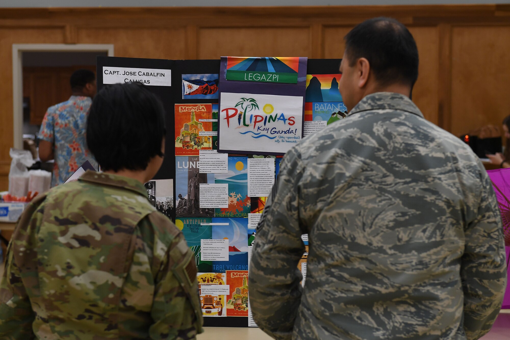 A man and a woman look at a poster board.