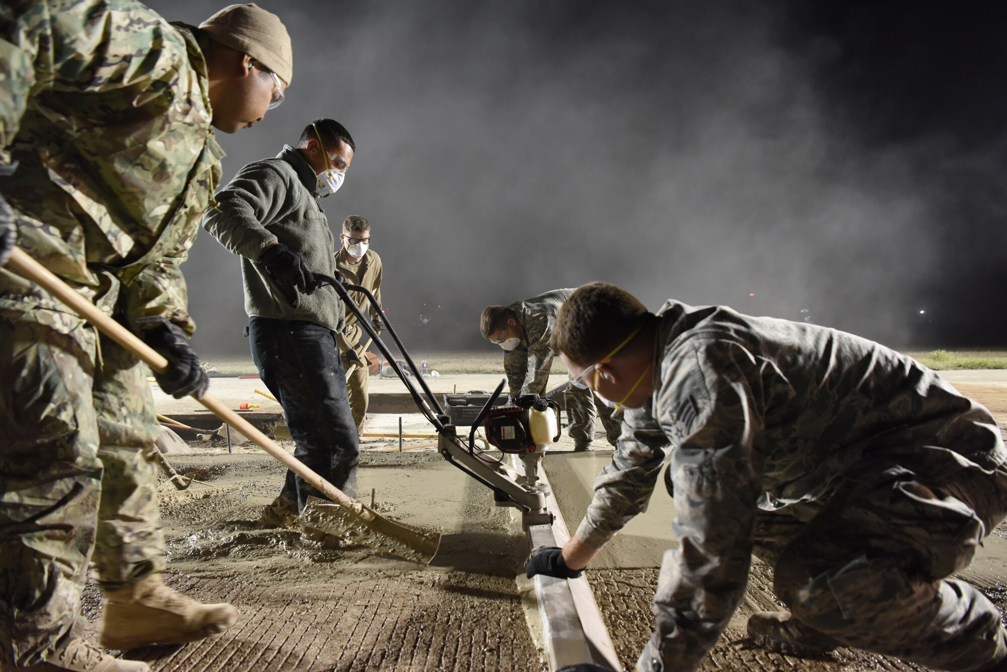 Airmen smooth concrete on the flight line