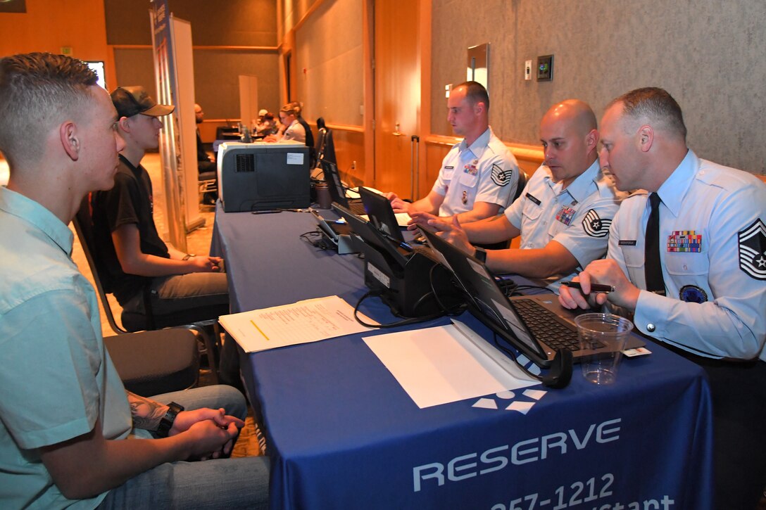 Recruiters speak to potential recruits during a hiring fair May 5 in Ogden, Utah