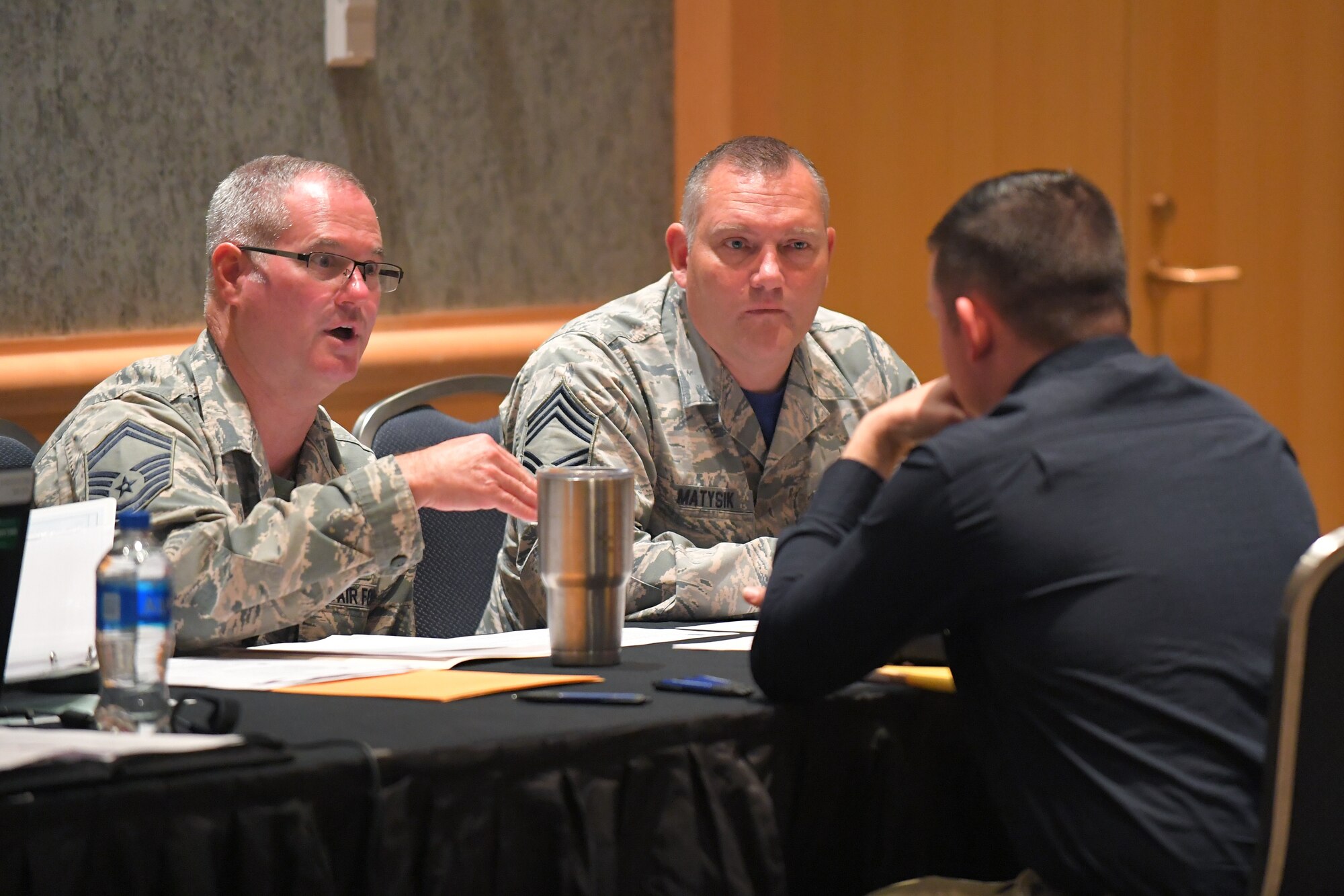 Senior Master Sgt. Craig Fowler (left) and Chief Master Sgt. Matthew Matysik speak with a potential recruit during a hiring fair